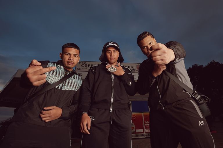 Promotional press photo of Australian drill group ONEFOUR wearing tracksuits outdoors at dusk, photographed by Cole Bennetts.